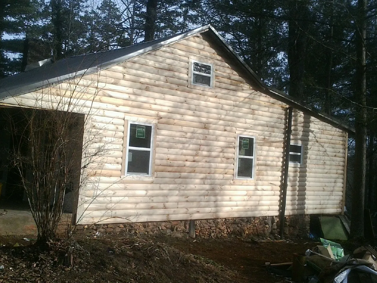 New log siding and dark metal roofing on a gable end in Jamison